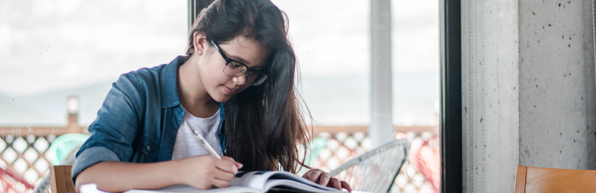 Female student studying at a table with books