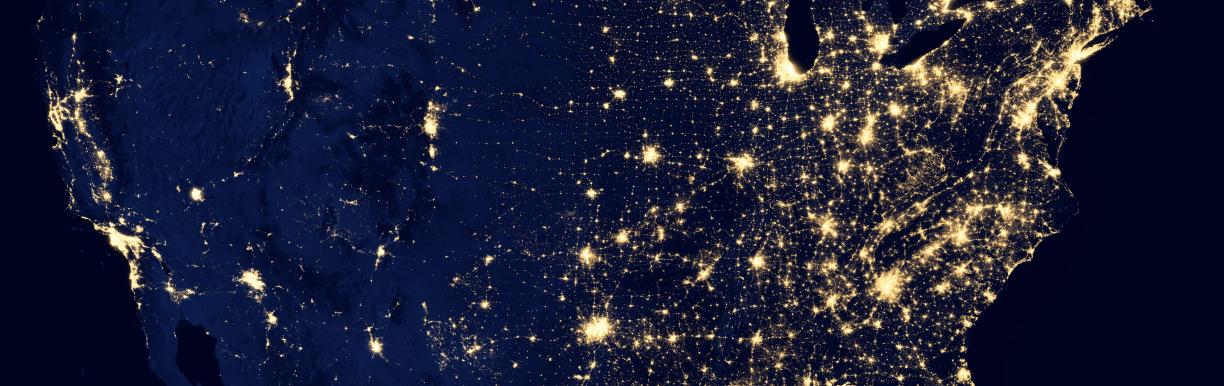 An image of the United States at night, from space, with light coming from major cities.